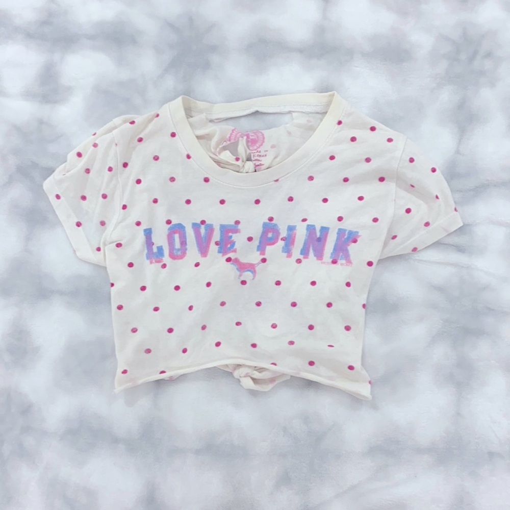 This is a white top with pink polkadots all over it. this shirt is from PINK.